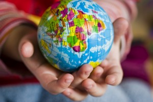 Child's hands holding a small globe